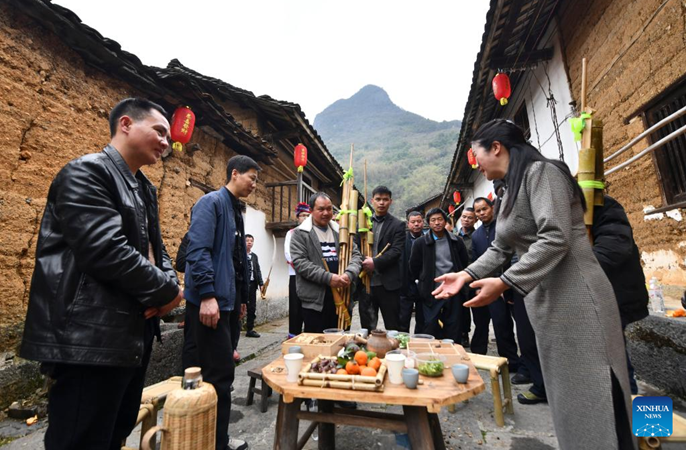 ชาวบ้านจากหมู่บ้านอู๋ยิงร่วมกับคนในท้องถิ่นดื่มชาที่ต้มจากเตาในหมู่บ้านตงปัน ตำบลตงฉี อำเภอ หรงอัน เขตปกครองตนเองจ้วงกว่างซี ทางตอนใต้ของจีน เมื่อวันที่ 18 กุมภาพันธ์ 2566 (ภาพจากซินหัว)