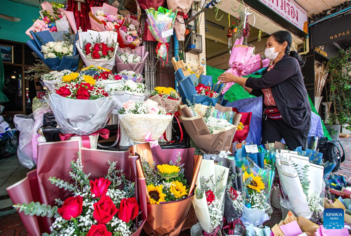 เจ้าของร้านดอกไม้ที่ปากคลองตลาดกรุงเทพมหานครจัดช่อดอกไม้ที่นำเข้ามาจากมณฑลยูนนานทางตะวันตกเฉียงใต้ของจีน เมื่อวันทึ่ 21 กุมภาพันธ์ 2566 (ซินหัว/หวาง เถิง)