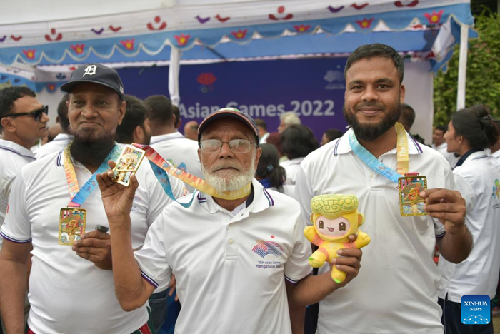 ผู้เข้าร่วมแข่งขันโชว์เหรียญรางวัลระหว่างการแข่งขันในงาน Hangzhou Asian Games Fun Run ที่กรุงธากา ประเทศบังกลาเทศ เมื่อวันที่ 17 พฤษภาคม 2566 (ซินหัว)