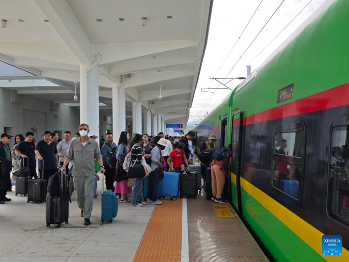 ผู้โดยสารต่อแถวขึ้นรถไฟที่สถานีหลวงพระบาง เมืองหลวงพระบาง สปป.ลาว เมื่อวันที่ 4 ธันวาคม พ.ศ. 2566 (ภาพโดย หลู่ อวิ้น/ซินหัว)