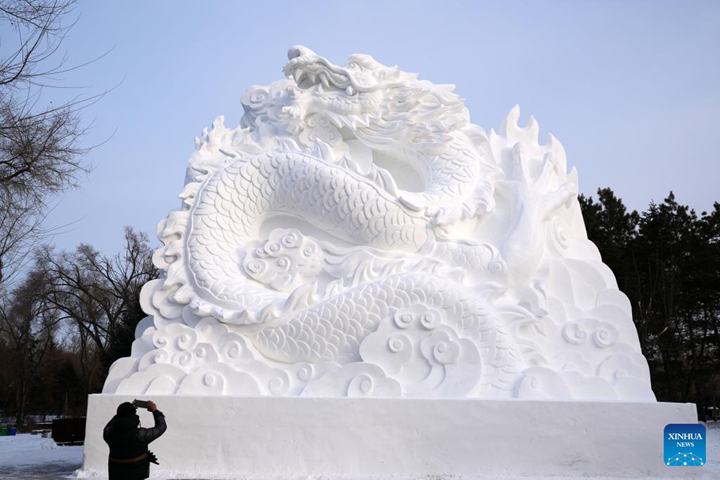 นักแกะสลักถ่ายรูปประติมากรรมแกะสลักหิมะที่เมืองฮาร์บิน มณฑลเฮยหลงเจียง ทางตะวันออกเฉียงเหนือของจีน เมื่อวันที่ 12 ธันวาคม 2566 (ซินหัว/หวาง เจี้ยนเวย)