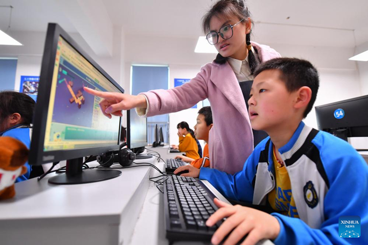 ครูกำลังสอนขณะที่นักเรียนใช้คอมพิวเตอร์ในวิชาเขียนโปรแกรมที่โรงเรียนประถมแห่งหนึ่งใน เมืองเซียงถัน มณฑลหูหนาน ทางตอนกลางของจีน เมื่อวันที่ 11 เมษายน 2567 เพื่อเสริมสร้างความรู้ทางวิทยาศาสตร์ของนักเรียนในท้องถิ่น โรงเรียนได้เพิ่มการเรียนการสอนที่เกี่ยวข้องกับทักษะทางวิทยาศาสตร์ เช่น หุ่นยนต์ การเขียนโปรแกรม โดรน และอื่น ๆ (ซินหัว)