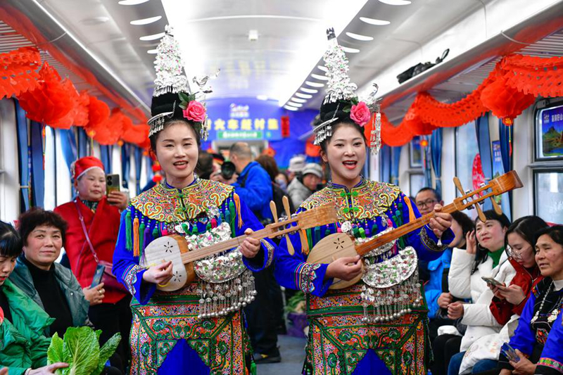 นักแสดงกลุ่มชาติพันธุ์กำลังแสดงบนขบวนรถไฟสายที่ 5640 ในมณฑลกุ้ยโจว ทางตะวันตกเฉียงใต้ของจีน เมื่อวันที่ 18 มกราคม 2568 (ซินหัว)