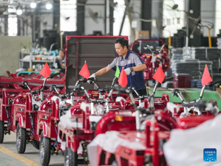 คนงานกำลังตรวจสอบรถสามล้อไฟฟ้าที่บริษัท Meishan Shuangsheng New Energy Vehicle Industry Co., Ltd ในเมืองเหมยซาน มณฑลเสฉวน ทางตะวันตกเฉียงใต้ของจีน ภาพถ่ายเมื่อวันที่ 28 เมษายน 2568 (ซินหัว)