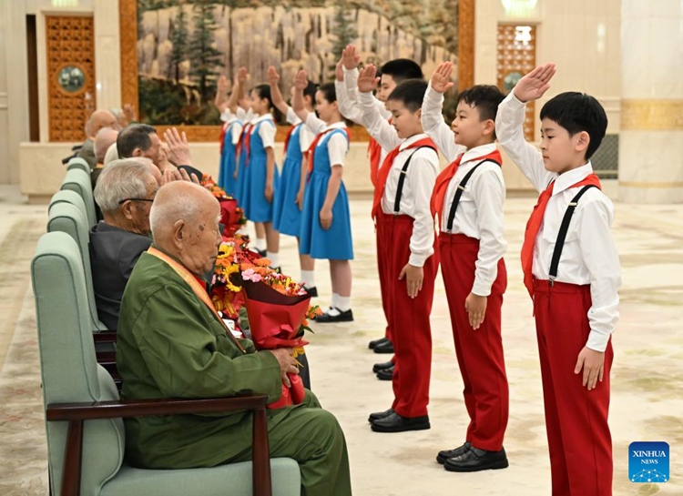 สมาชิกกลุ่ม Chinese Young Pioneers มอบดอกไม้ให้กับทหารผ่านศึกก่อนงานกาล่าวัฒนธรรมอันยิ่งใหญ่ ณ อาคารมหาศาลาประชาชนที่กรุงปักกิ่ง เมืองหลวงของจีน เมื่อวันที่ 3 กันยายน 2568 (ซินหัว)
